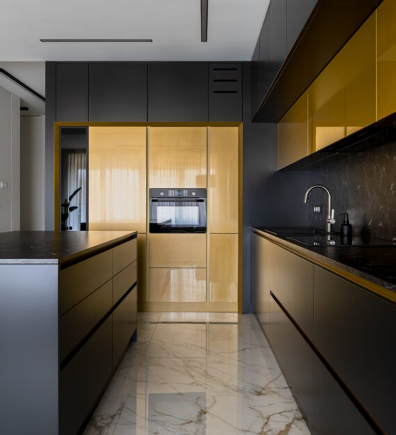 Elegant kitchen with black and gold furniture, kitchen island and marble floor tiles